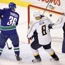 Nashville Predators defenseman Klein and Blum watch with Vancouver Canucks right wing Hansen as Higgins' shot gets past goalie Rinne in Vancouver