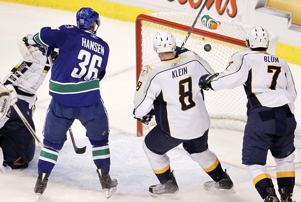 Nashville Predators defenseman Klein and Blum watch with Vancouver Canucks right wing Hansen as Higgins' shot gets past goalie Rinne in Vancouver
