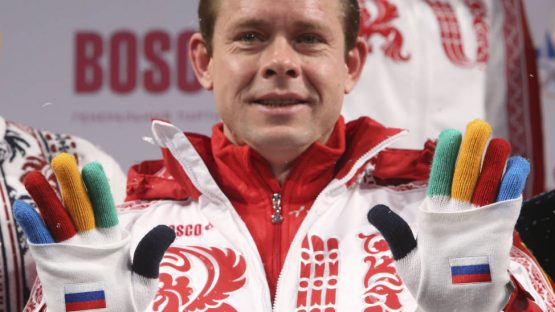 Former Russian ice-hockey player Bure shows a pair of gloves during a presentation of Russia's uniform for the Sochi 2014 Winter Olympics in Moscow
