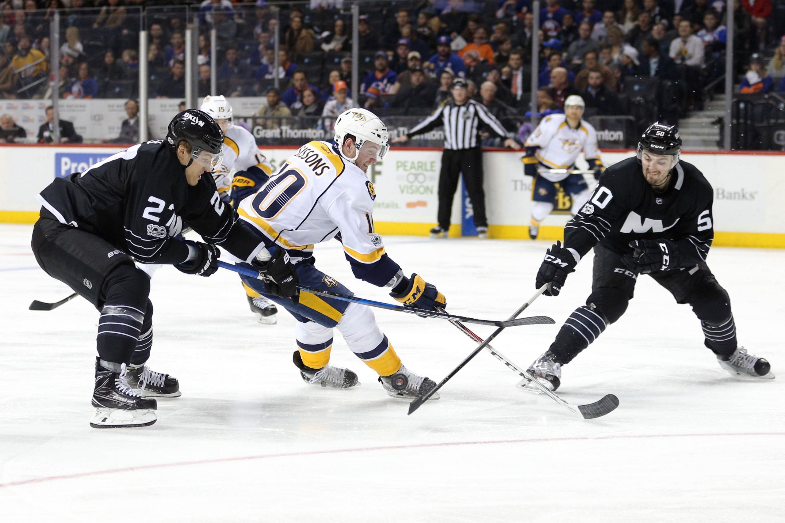 Mar 27, 2017; Brooklyn, NY, USA; Nashville Predators center Colton Sissons (10) plays the puck against New York Islanders center Anders Lee (27) and New York Islanders defenseman Adam Pelech (50) during the third period at Barclays Center. Mandatory Credit: Brad Penner-USA TODAY Sports