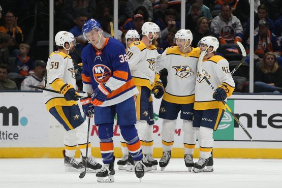 Dec 17, 2019; Uniondale, NY, USA; Nashville Predators defenseman Mattias Ekholm (14) celebrates his goal against the New York Islanders with teammates in front of Islanders left wing Ross Johnston (32) during the second period at Nassau Veterans Memorial Coliseum. Mandatory Credit: Brad Penner-USA TODAY Sports