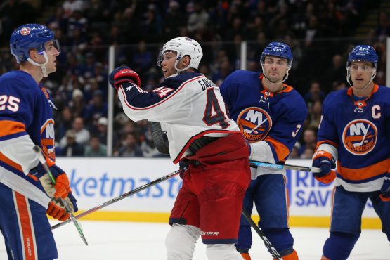 Dec 23, 2019; Uniondale, New York, USA; Columbus Blue Jackets defenseman Vladislav Gavrikov (44) reacts after scoring the game winning goal against New York Islanders defenseman Devon Toews (25) and defenseman Adam Pelech (3) and left wing Anders Lee (27) during the third period at Nassau Veterans Memorial Coliseum. Mandatory Credit: Brad Penner-USA TODAY Sports