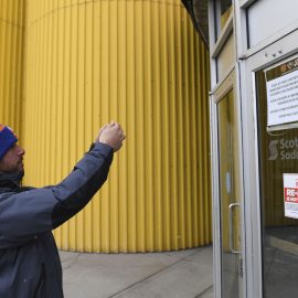 Mar 12, 2020; Calgary, Alberta, CAN; Joe Cosmo, from Long Island, NY takes a photo of the closure notice at the Scotiabank Saddledome after the announcement by the NHL of the suspension of NHL play due to the coronavirus. Cosmo travelled from New York to see the Islanders play the Flames on Wednesday night as part of his goal to see the Islanders play in all 31 NHL arenas. Mandatory Credit: Candice Ward-USA TODAY Sports