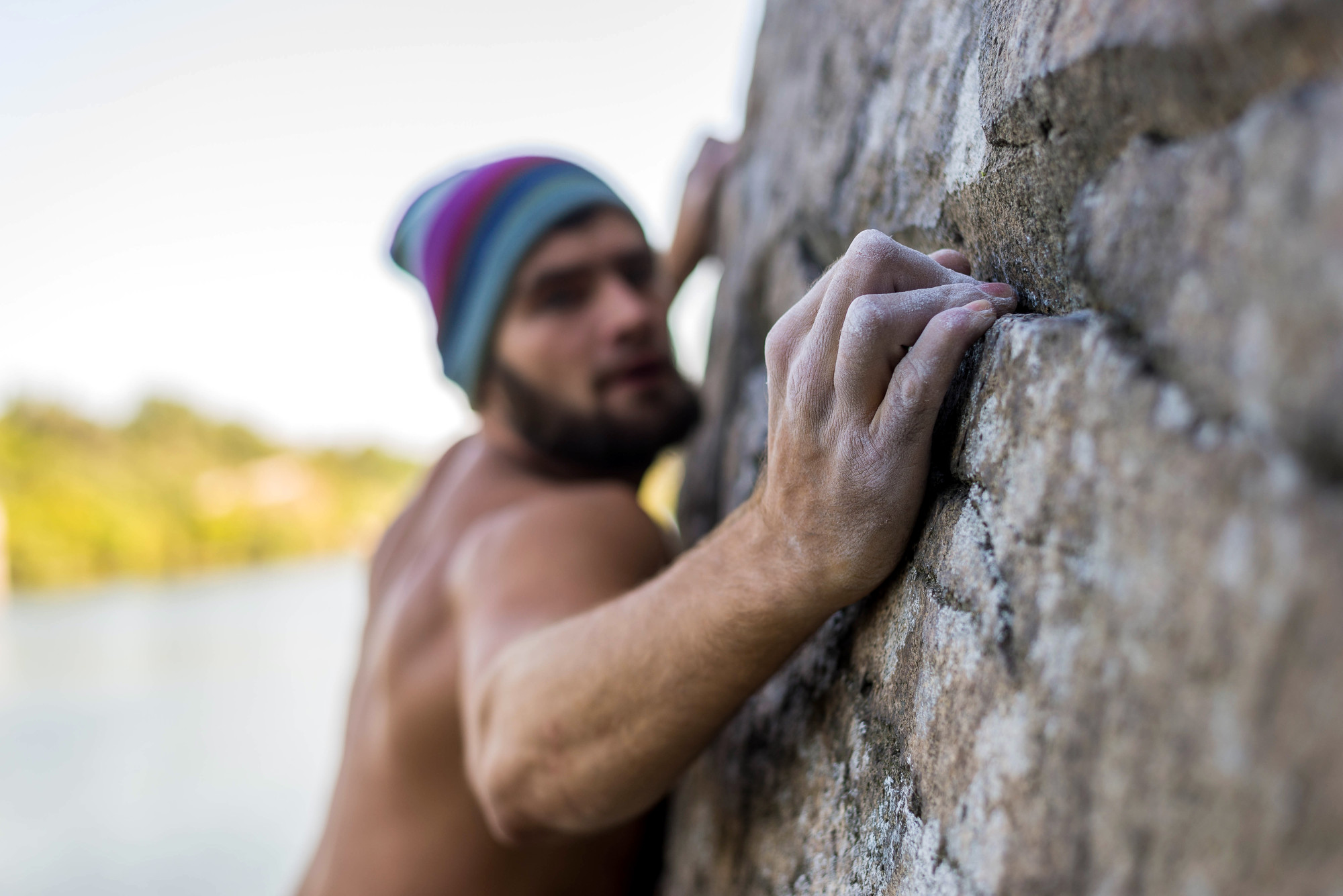 Portrait of a man climber climbing to the top of the rock.