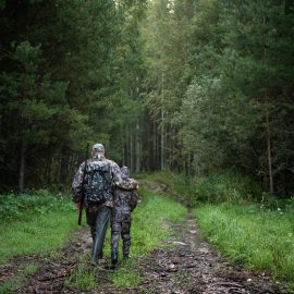 father pointing and guiding son on first deer hunt