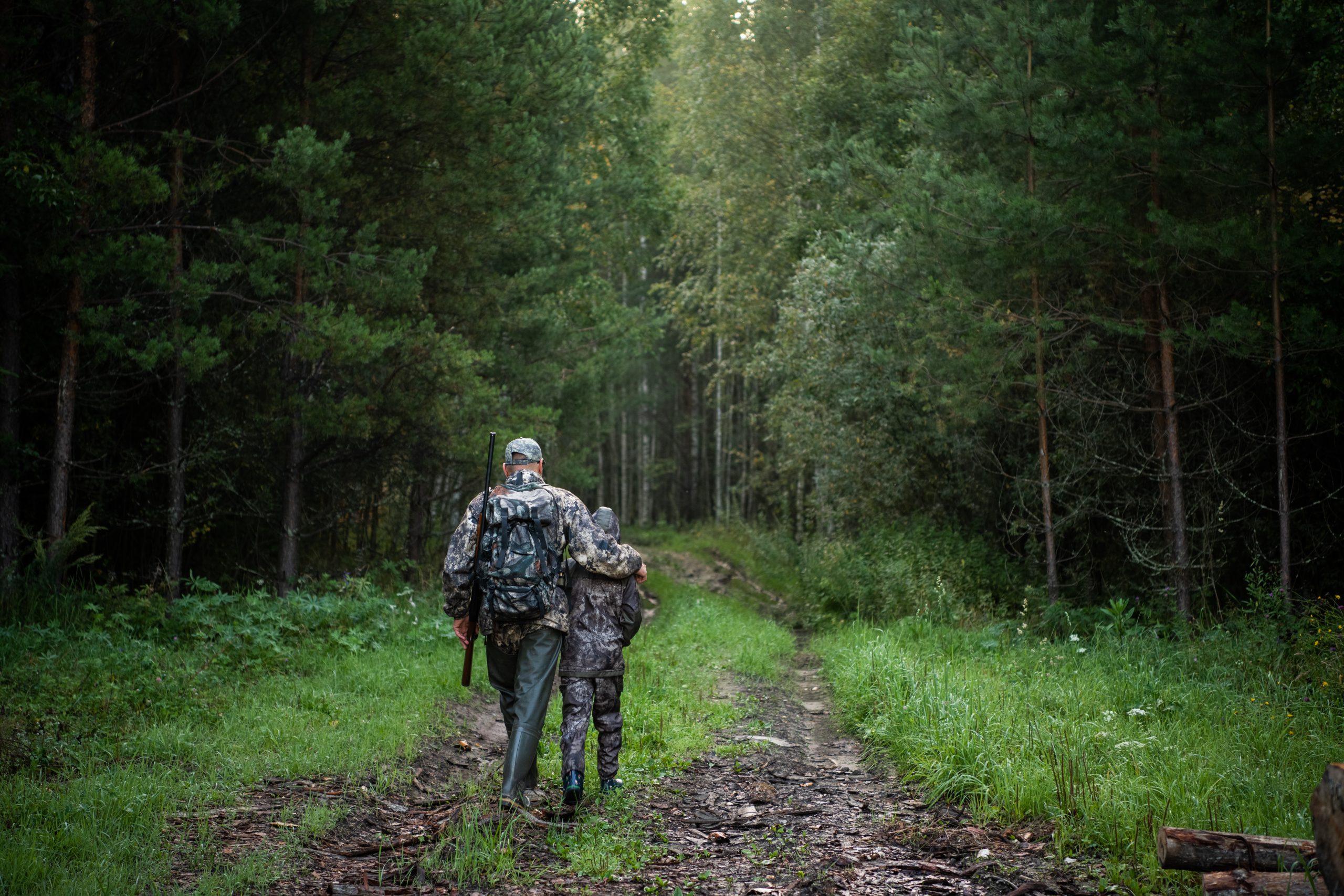 father pointing and guiding son on first deer hunt