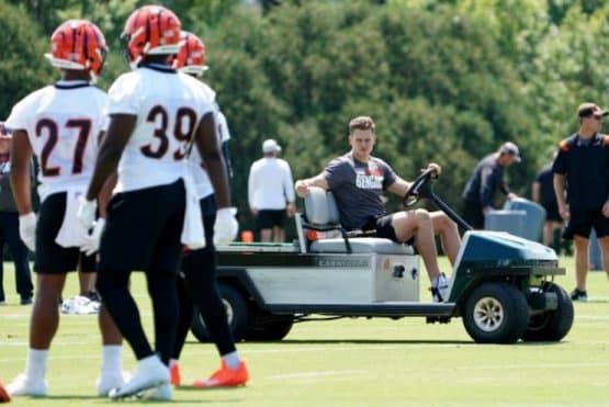 Watch a hilarious viral video of Cincinnati Bengals quarterback Joe Burrow driving a cart while his teammates run after practice.