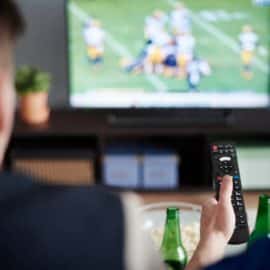 Young adult men friends watching American football