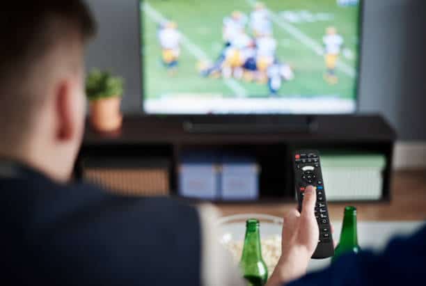 Young adult men friends watching American football