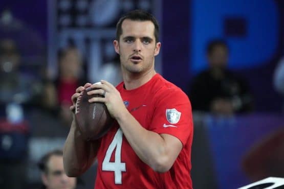 Derek Carr holds a football.