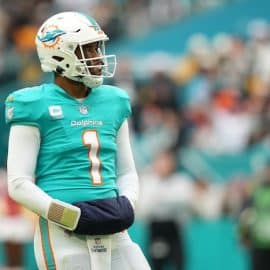 Miami Dolphins quarterback Tua Tagovailoa puts hands in warmer.