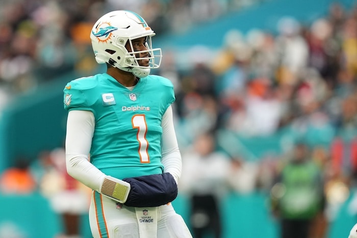Miami Dolphins quarterback Tua Tagovailoa puts hands in warmer.