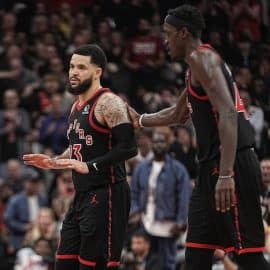 Toronto Raptors guard Fred VanVleet walks next to a player.
