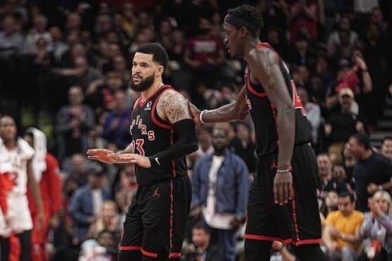 Toronto Raptors guard Fred VanVleet walks next to a player.