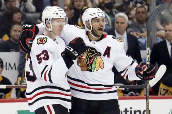 Two Blackhawks celebrate a goal.