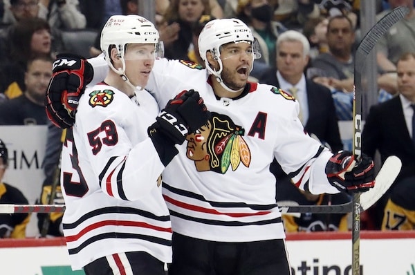 Two Blackhawks celebrate a goal.