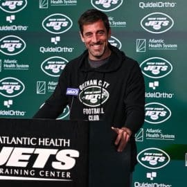New York Jets quarterback Aaron Rodgers stands at the podium.