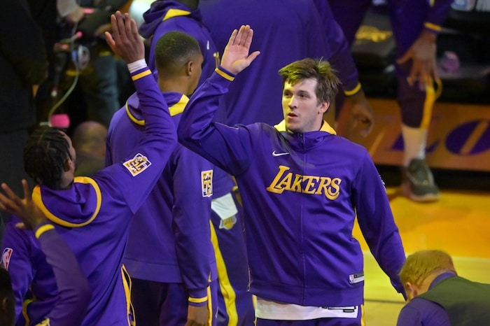 Austin Reaves high fives a player.