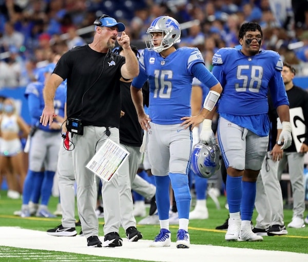 Head coach Dan Campbell talks with Detroit Lions quarterback Jared Goff