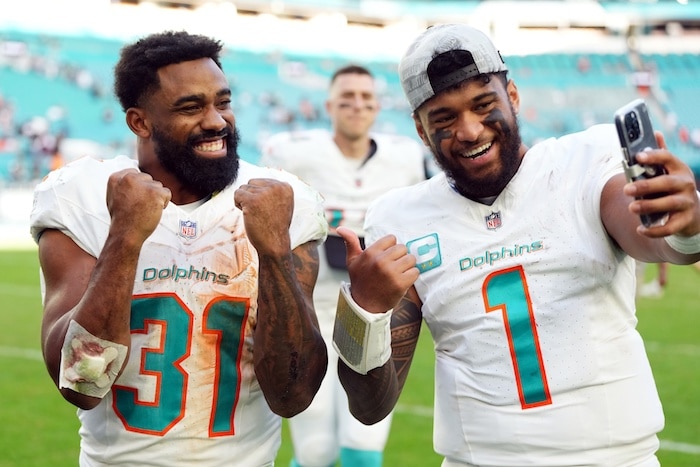 Miami Dolphins quarterback Tua Tagovailoa (1) and running back Raheem Mostert (31)