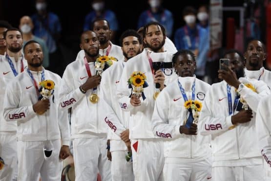 Team USA watches the American flag raised during the national anthem