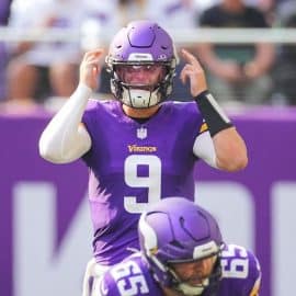 Minnesota Vikings quarterback J.J. McCarthy points to his head.