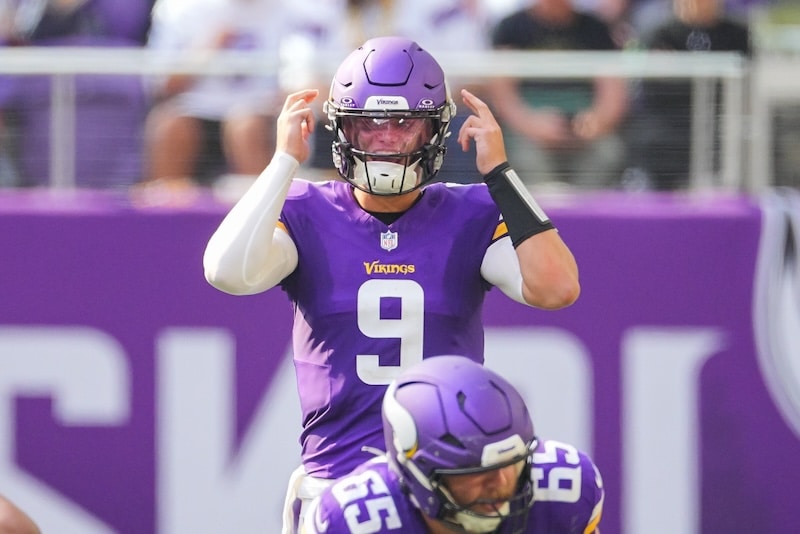Minnesota Vikings quarterback J.J. McCarthy points to his head.