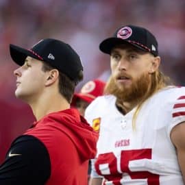 San Francisco 49ers quarterback Brock Purdy (left) with tight end George Kittle stand on the sideline.