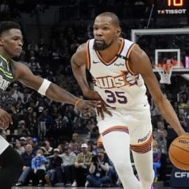 Kevin Durant dribbles the ball by Anthony Edwards.