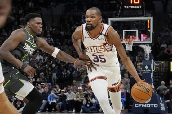 Kevin Durant dribbles the ball by Anthony Edwards.
